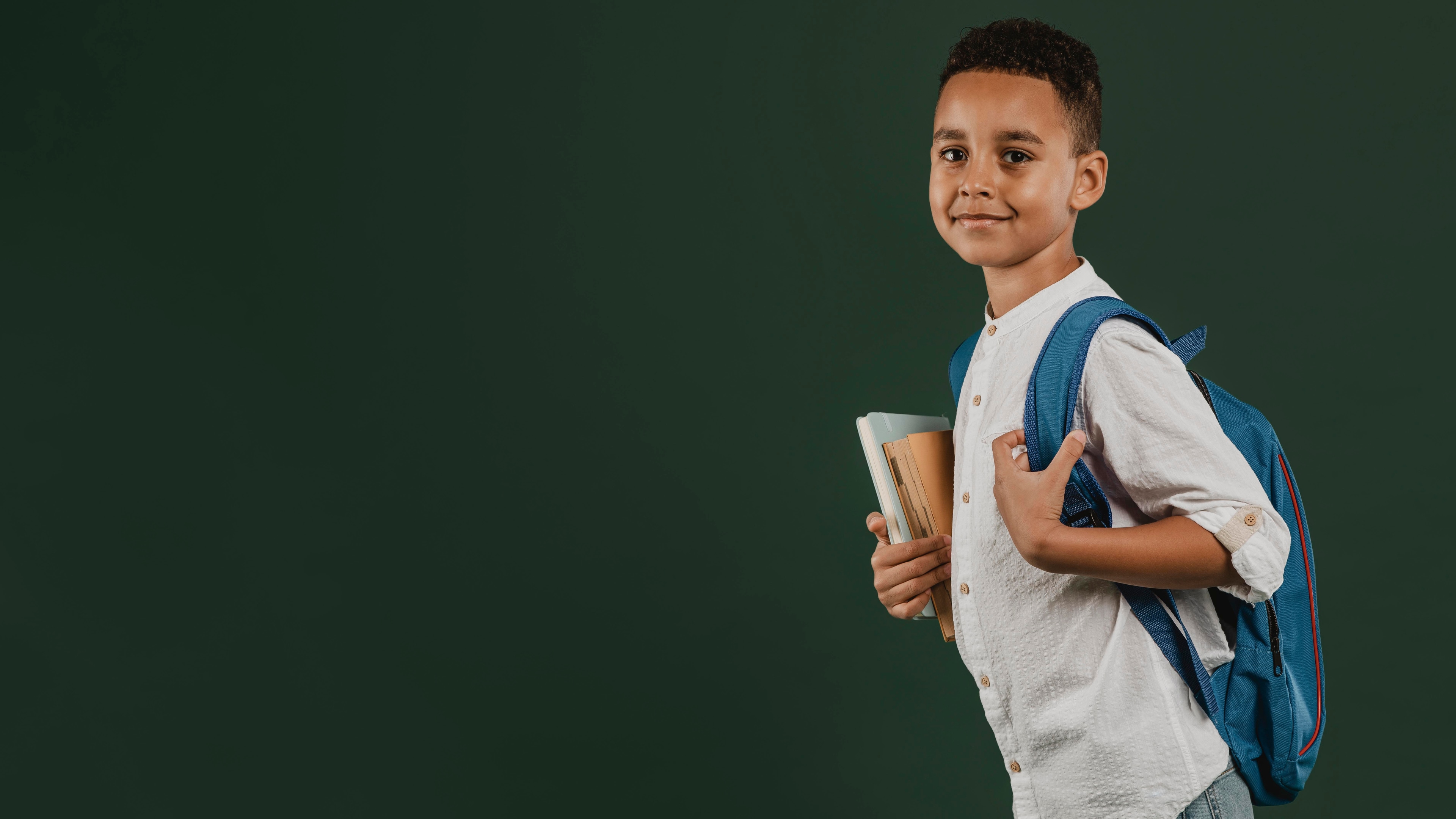 Student with backpack and books in a modern Kenyan school